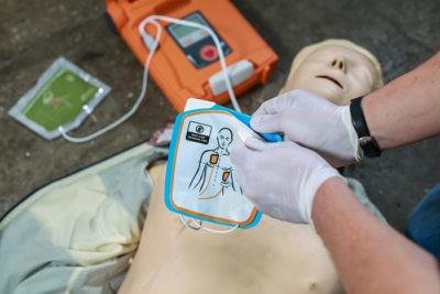 a nurse using a AED on a doll