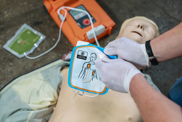 a nurse using a AED on a doll
